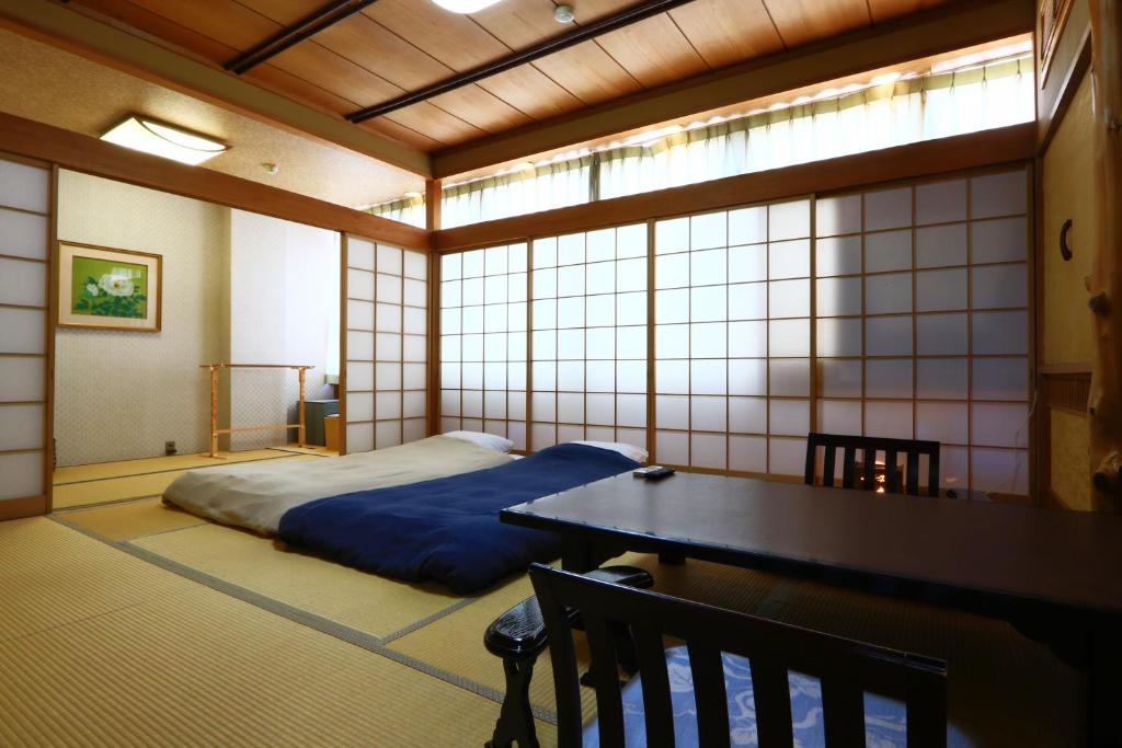 a room with a bed and a table in it at 割烹旅館小川荘 in Ōmiya