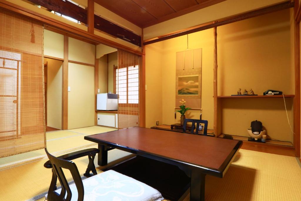 a dining room with a wooden table and chairs at 割烹旅館小川荘 in Ōmiya