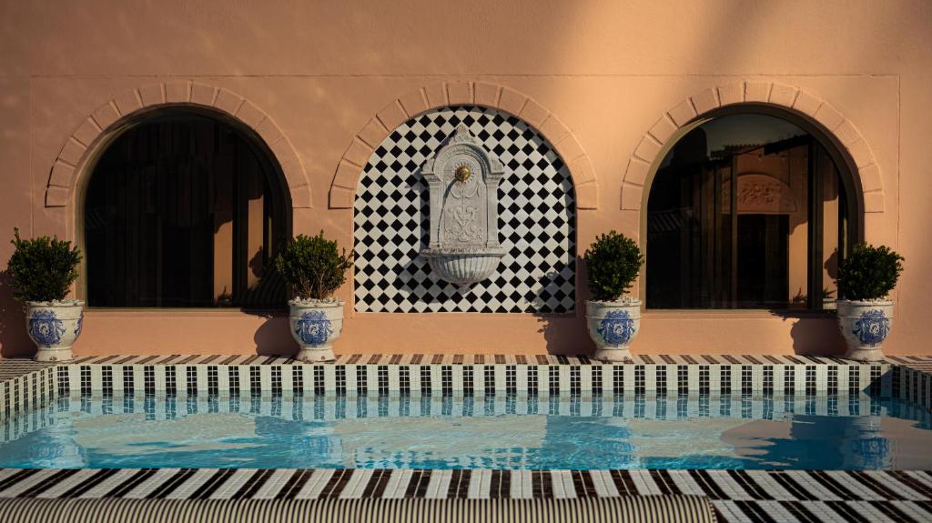 a swimming pool with three potted plants in a building at The Trade Boutique Hotel in Cape Town
