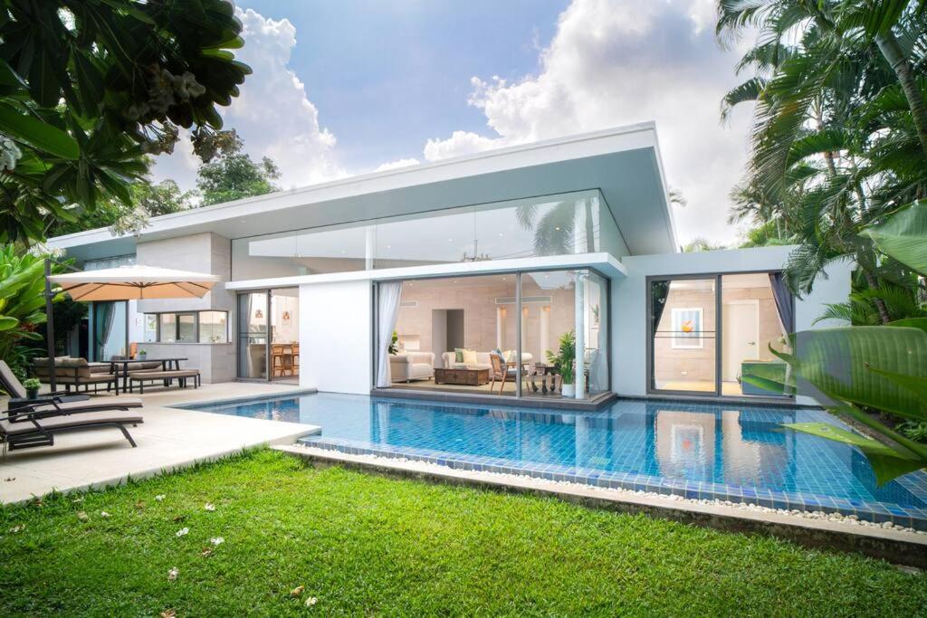 a house with a swimming pool in front of it at Modern Tranquillity Pool Villa, Layan in Laguna Phuket
