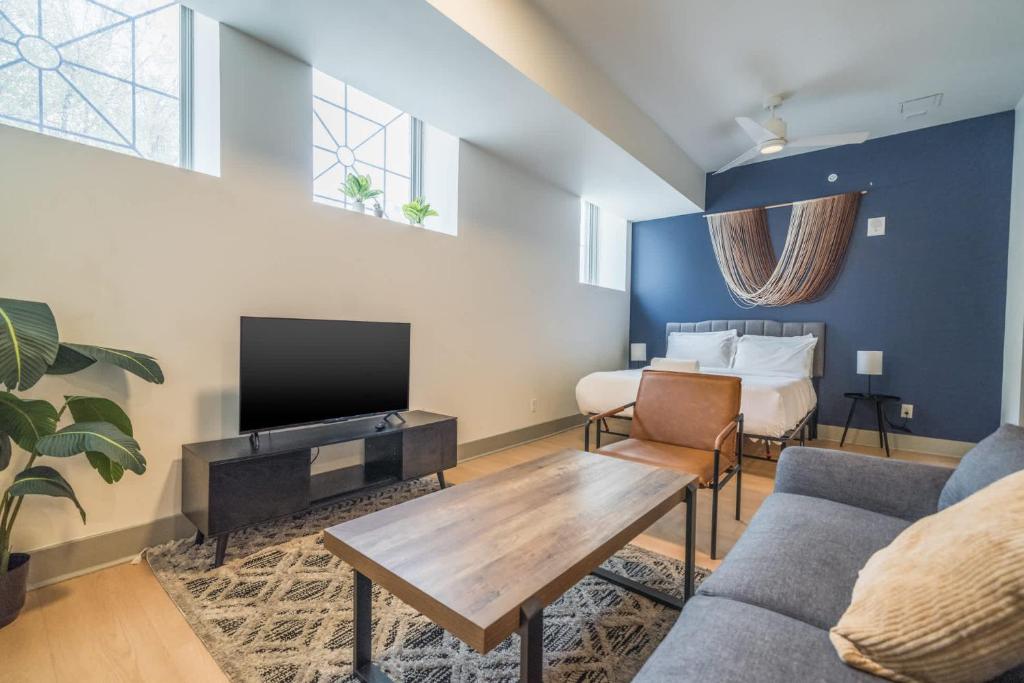 Una sala de estar con un sofá, un televisor y una cama. en Bright and Modern Studio in Louisville # 106, en Louisville