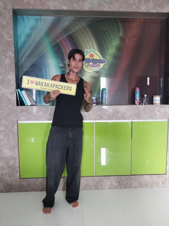 a man holding a sign that says i maximize players at WakakaPackers in Kuala Lumpur