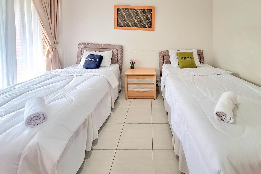 Postel nebo postele na pokoji v ubytování Urbanview Hotel Tridaya Cisarua Puncak