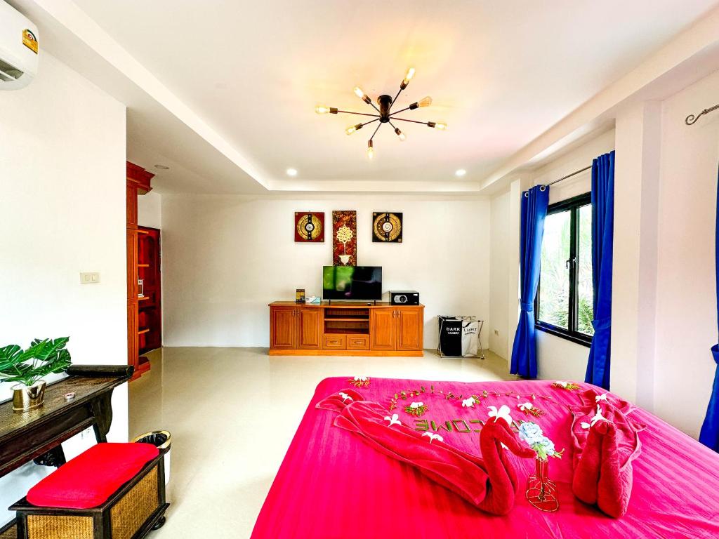 - une chambre avec un lit rose et une télévision dans l'établissement Amara Beach Resort Koh Phangan, à Haad Yao