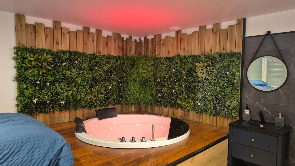 a room with a bath tub with a green wall at Balnéo Nuits Tranquilles Rouen in Rouen