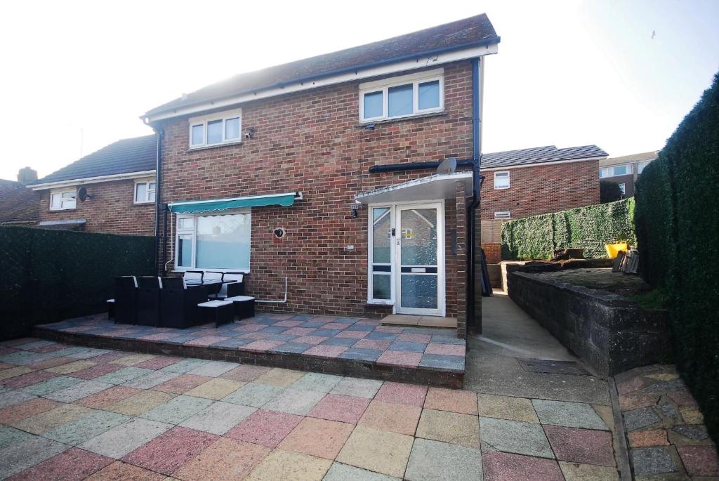 a brick house with a patio in front of it at Charming Retreat With Hot Tub Sauna Sleeps 4 in Falmer