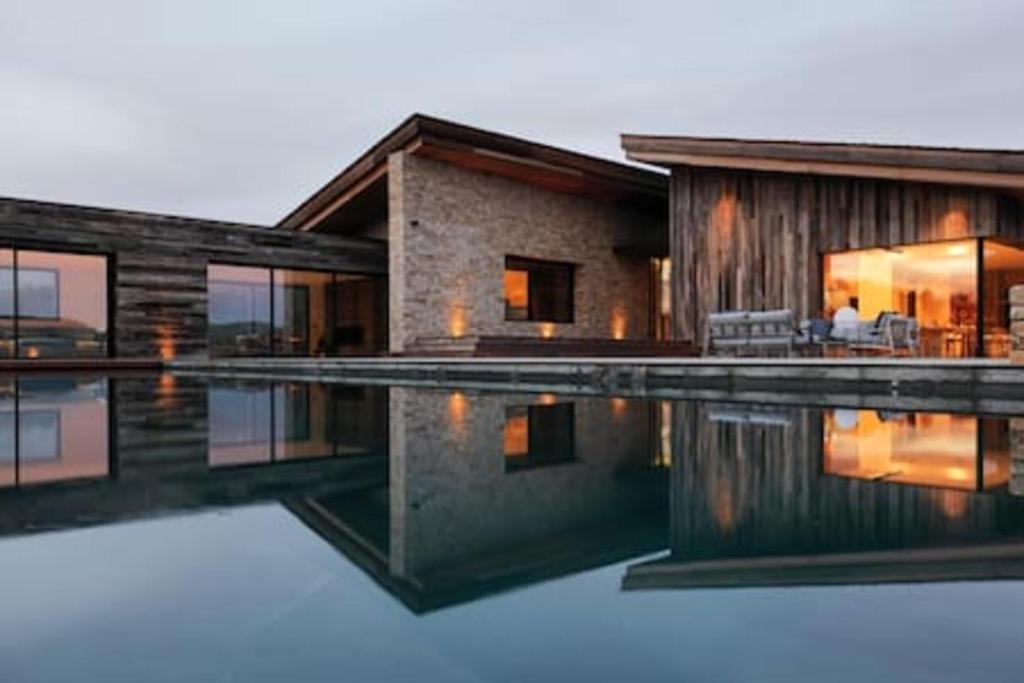 une maison avec une piscine devant dans l'établissement Villa Wooden Horizon - Mer Montagne 18 pers, à Porto-Vecchio