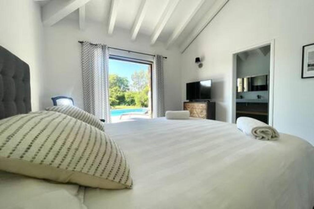 Un dormitorio blanco con una cama grande y una ventana. en Villa à Marina di Fiori - 8 pers, en Porto Vecchio