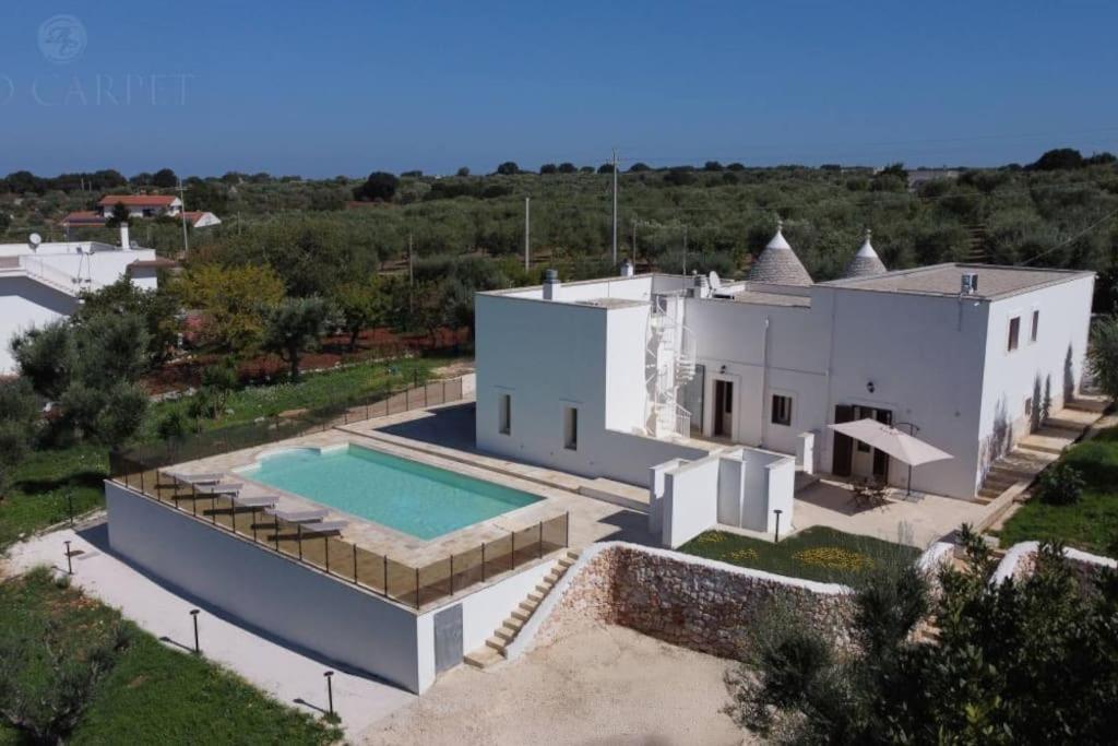an aerial view of a white house with a swimming pool at Masseria Comara in Monopoli