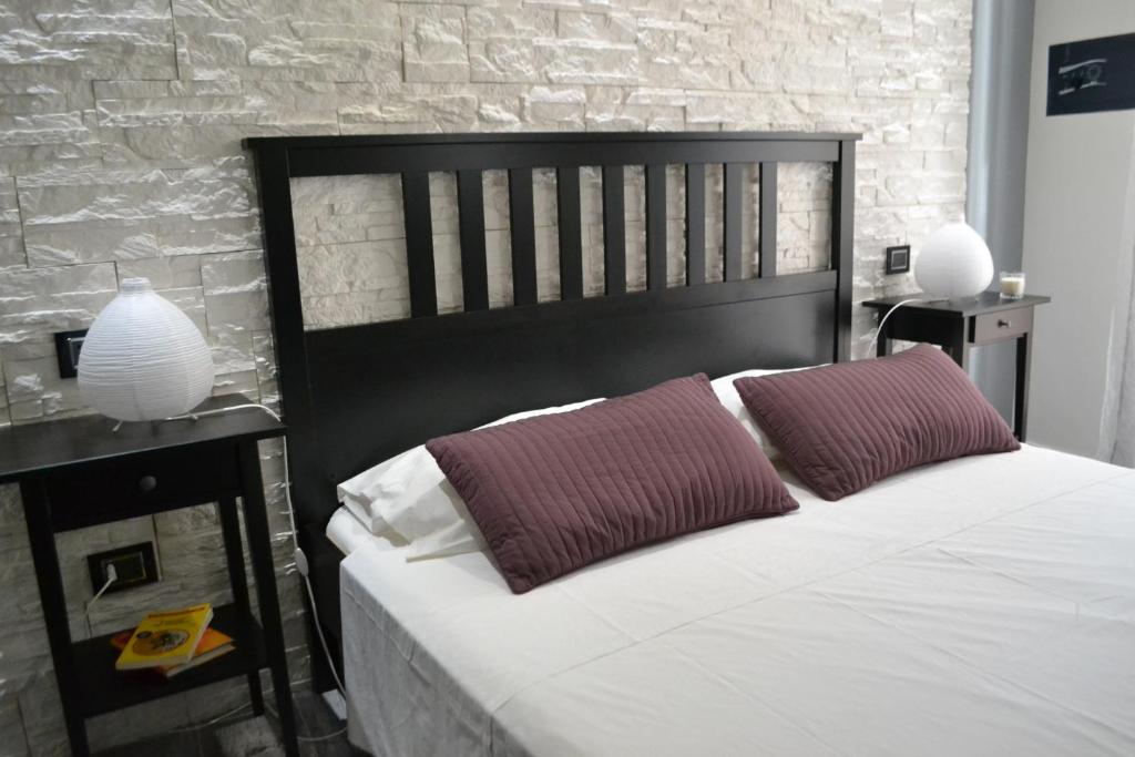 um quarto com uma cama grande e 2 almofadas vermelhas em B&B O Casteddu em Monforte San Giorgio