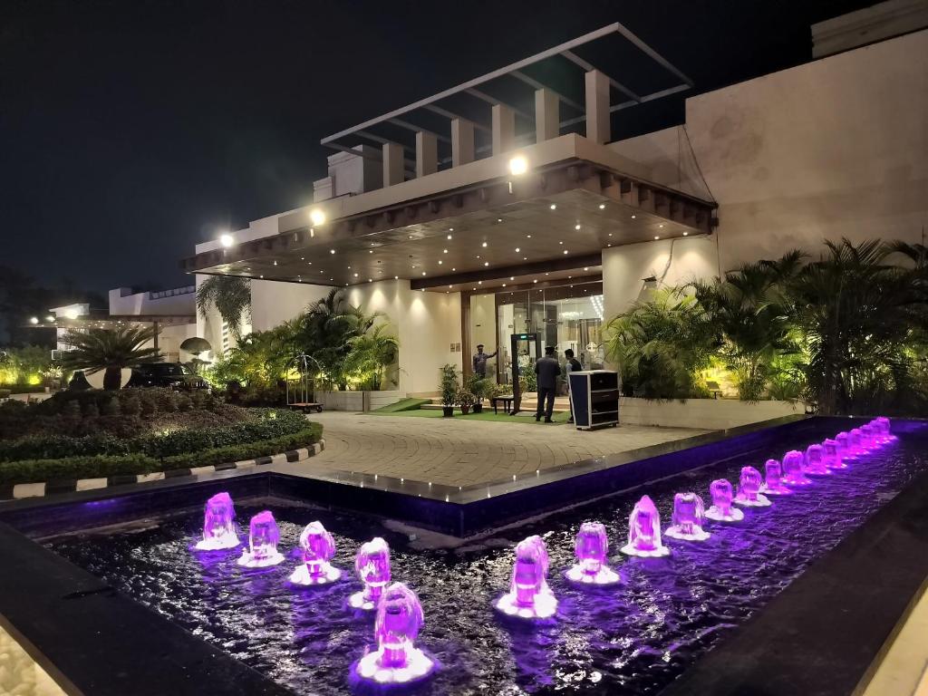 a building with a bunch of pink flamingos in a pond at Bel-La Monde Hotel NH8 at 6km from IGI Airport Delhi in New Delhi