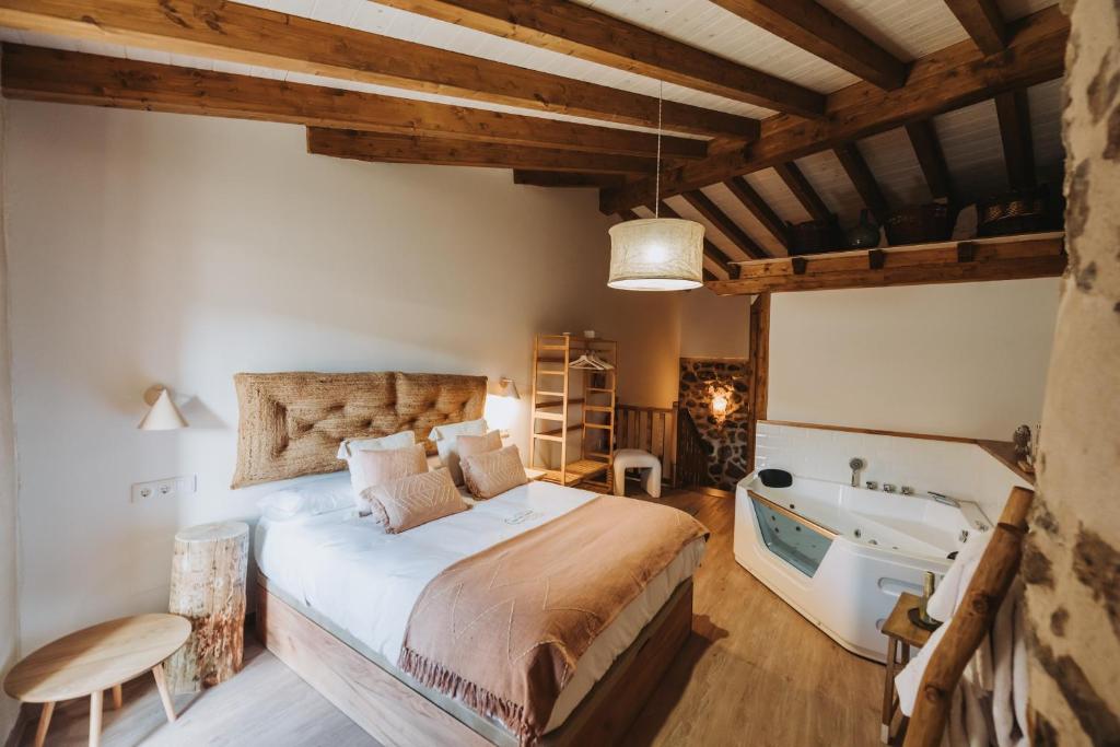 a bedroom with a bed and a tub and a sink at La casa del Mayoral in Tremedal