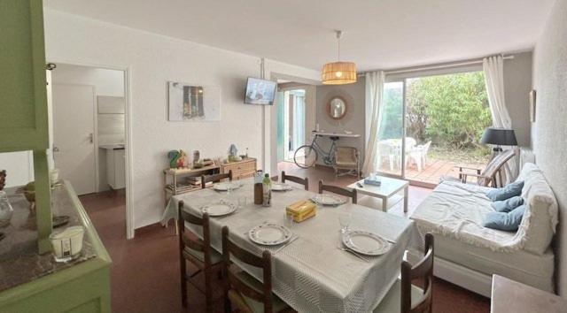 un salon avec une table et un canapé dans l'établissement Agréable maison familiale face à la mer 6LLN21, au Barcarès