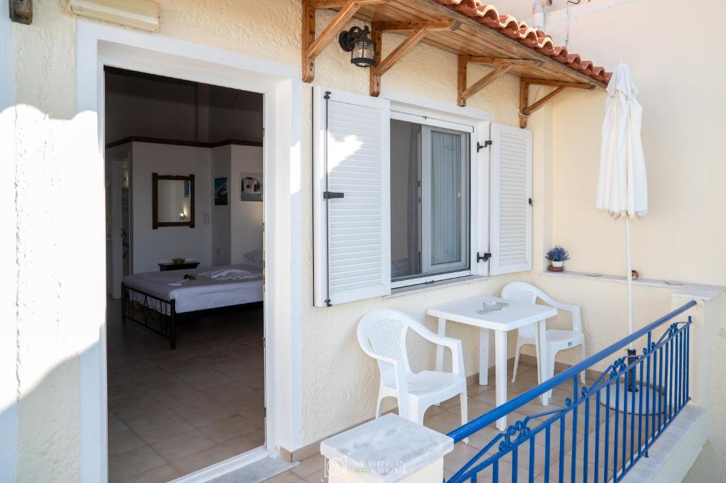 a balcony with a table and chairs on a house at Elli Studios & Apartments in Marathokampos
