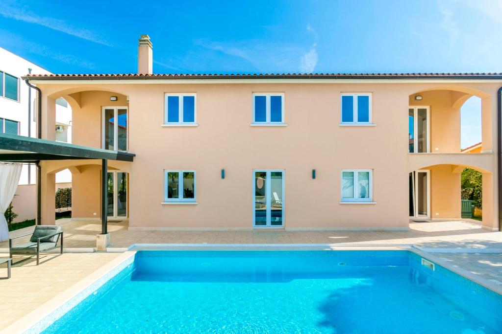 a villa with a swimming pool and a house at Villa Suzy in Medulin