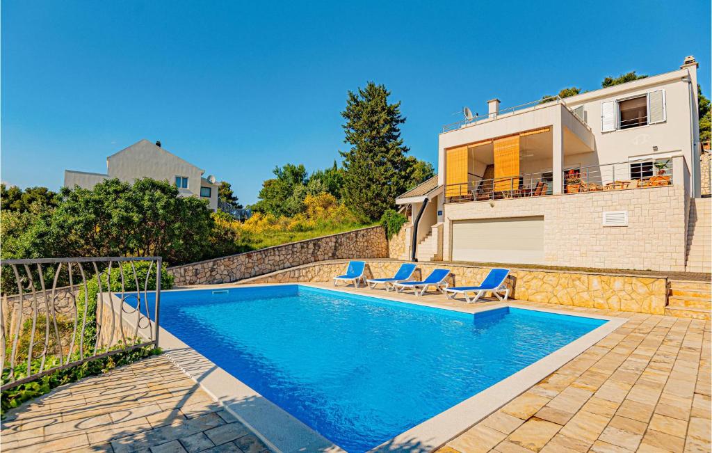 a swimming pool with two chairs and a house at Awesome Home In Zaboric With Wifi in Zaboric