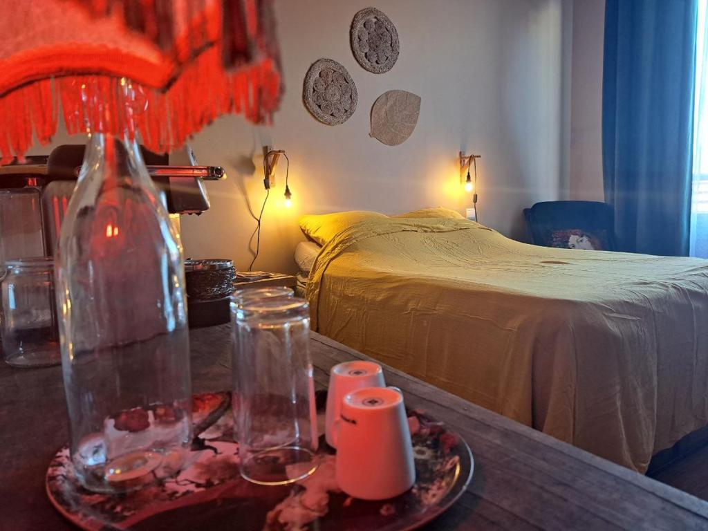 Un dormitorio con una cama y una mesa con un jarrón. en chambre cosy en centre ville avec accès indépendant, en Châtellerault