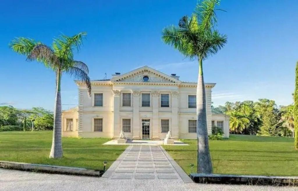 a large white house with two palm trees at Chateau Le Marais in Wallis Island