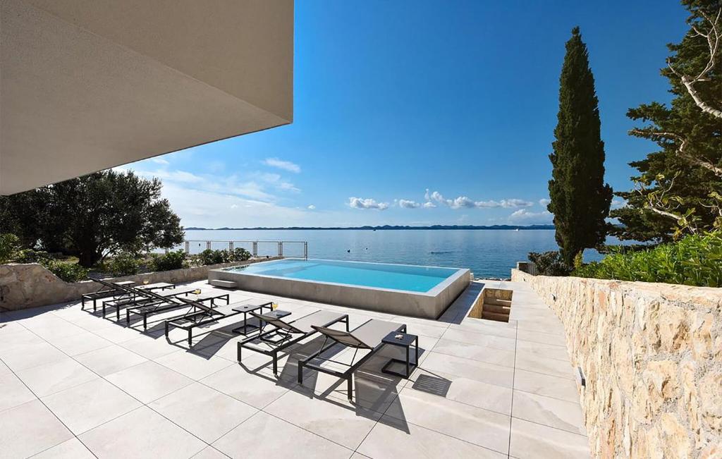 a group of chairs sitting next to a swimming pool at Awesome Home In Zdrelac in Ždrelac