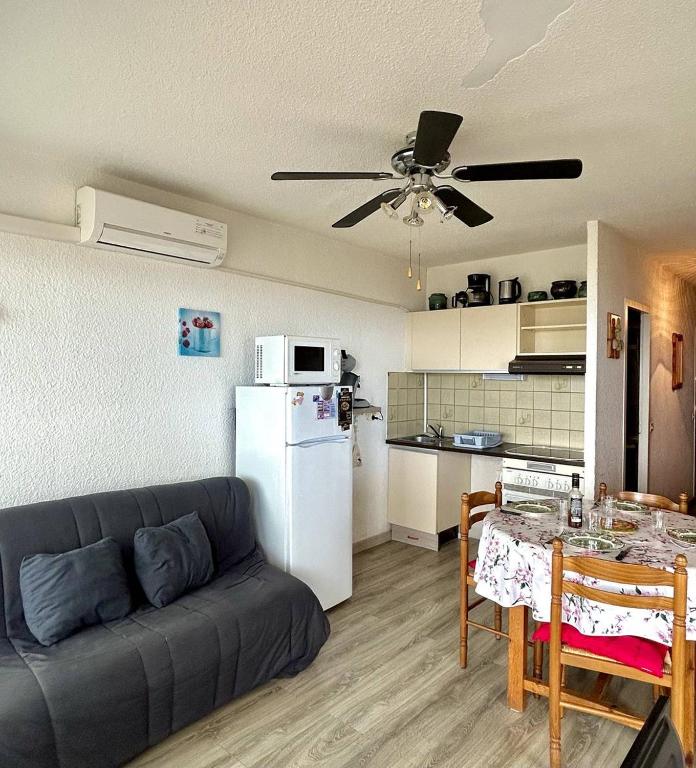 un salon avec un canapé et une cuisine dans l'établissement Confortable T2 + Cabine face à la mer 4BALM39, au Barcarès