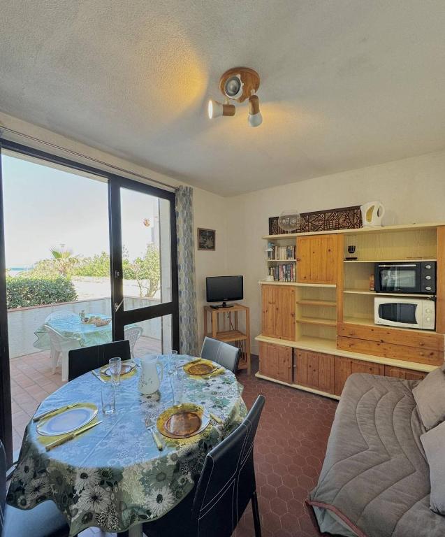 un salon avec une table et une cuisine dans l'établissement Accès direct plage - parking privé - appartement 4 personnes 4MIR7BAT8, au Barcarès