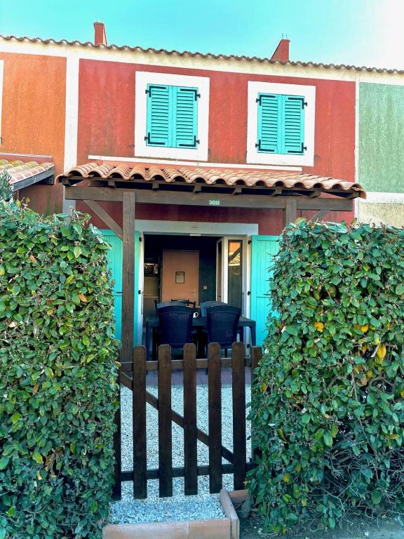 une maison avec une clôture devant dans l'établissement Agréable maisonnette piscine collective 4IDP3031, au Barcarès