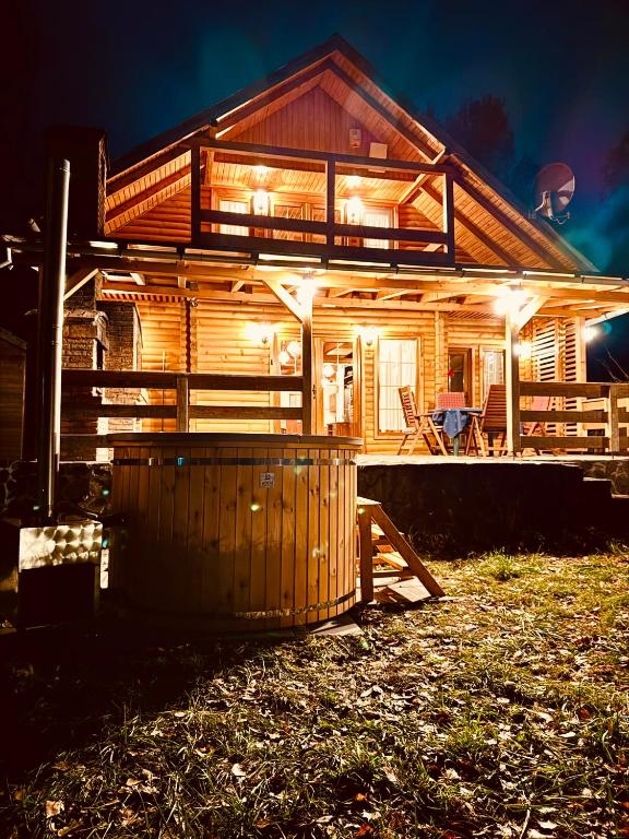 a wooden house with lights on the front of it at Hillside Praid in Praid