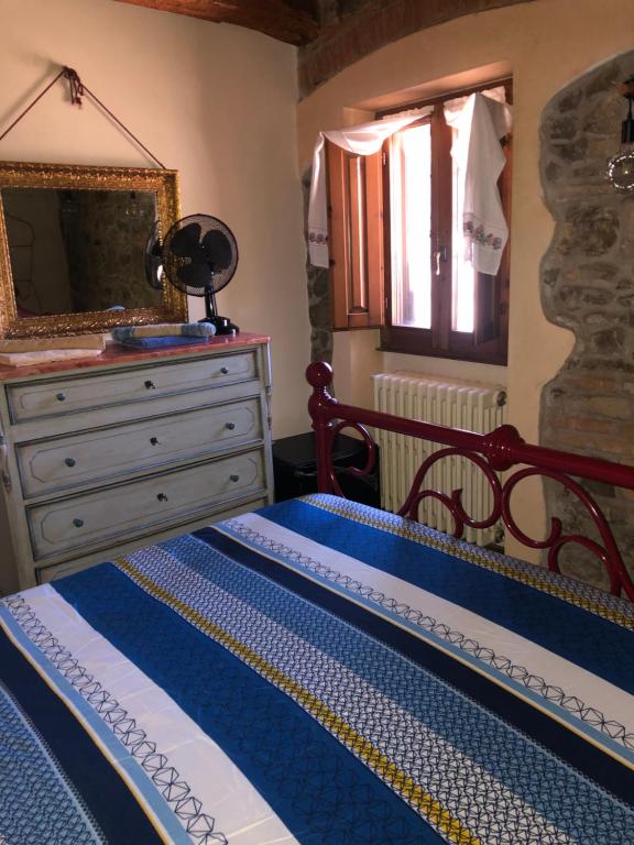 a bedroom with a bed and a dresser and a mirror at W il silenzio! in Gualdo
