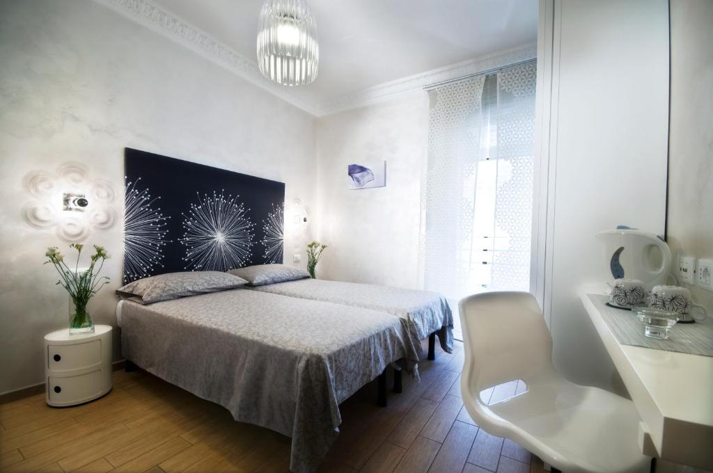 um quarto branco com uma cama e uma cadeira branca em Domus Diana em Roma