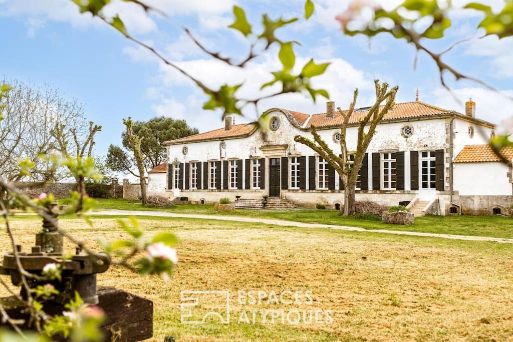 Elle offre une vue sur l'extérieur d'un grand bâtiment blanc doté de fenêtres. dans l'établissement Domaine historique entre mer et campagne, à Dolus-d'Oléron
