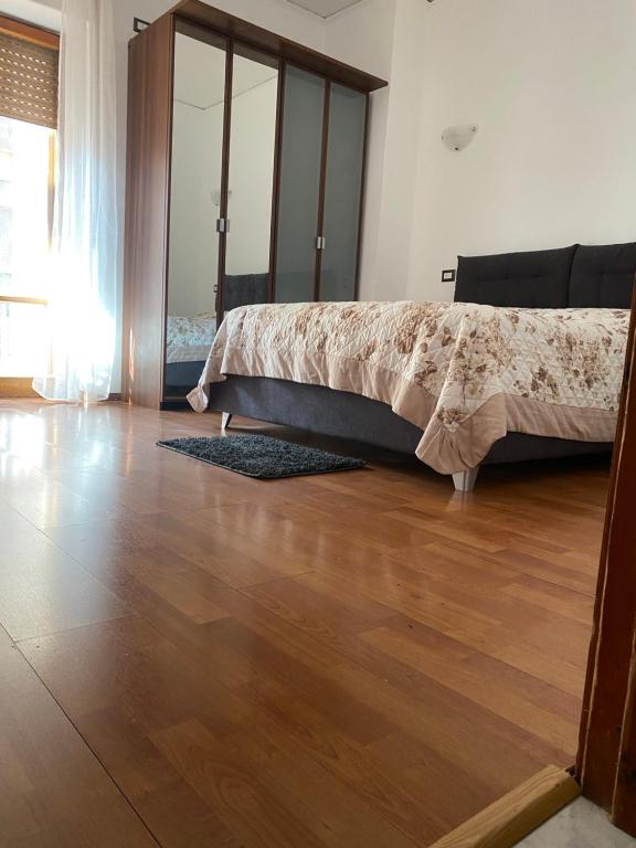 a bedroom with a bed and a wooden floor at 4routes house in Salerno