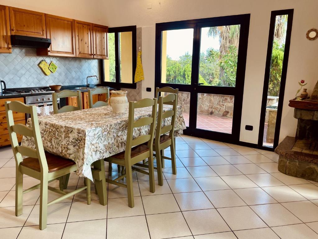 a kitchen with a table with chairs and a table and a table and a kitchen at Villa Giulia in Is Molas 