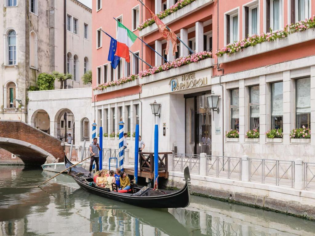 a group of people in a gondola on a canal at Papadopoli Hotel Venezia - MGallery Collection in Venice