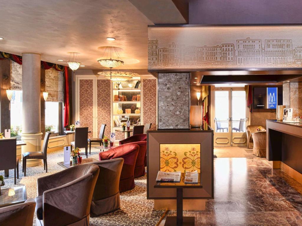 a lobby of a hotel with a couch and chairs at Papadopoli Hotel Venezia - MGallery Collection in Venice