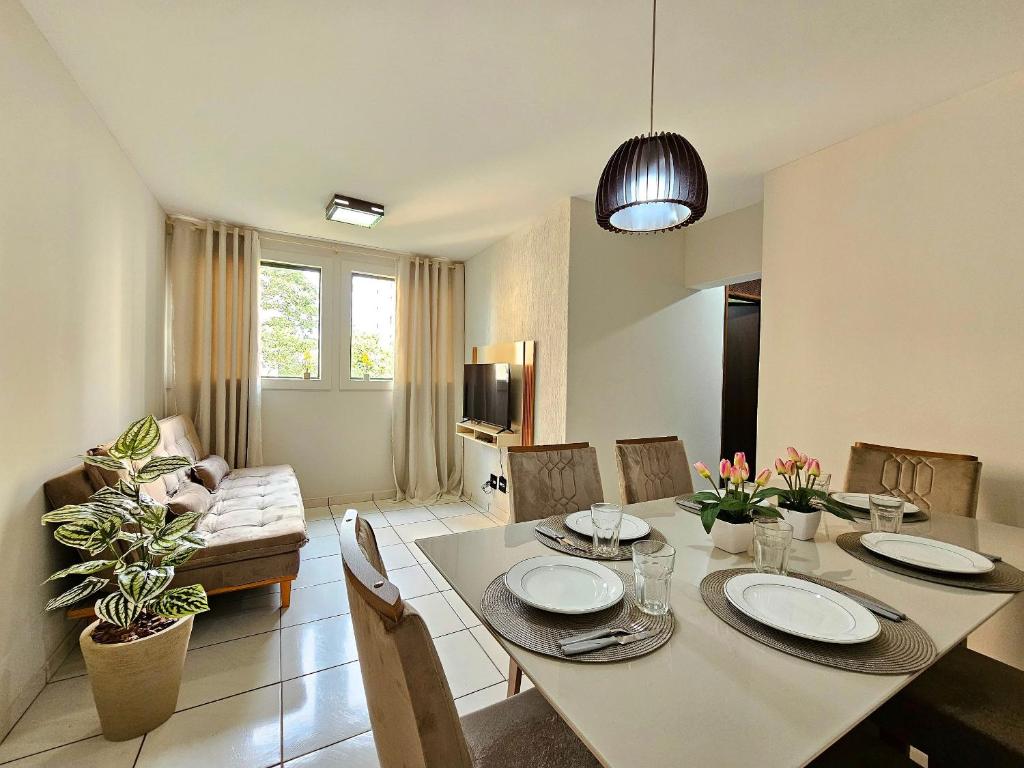 une salle à manger et un salon avec une table et des chaises dans l'établissement Apt 402 com 3 quartos 10min Paraguai e 5min centro, à Foz do Iguaçu