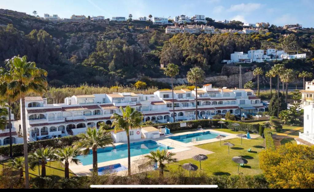 an image of a resort with a swimming pool and palm trees at Casa Playa Paraiso Manilva in Manilva