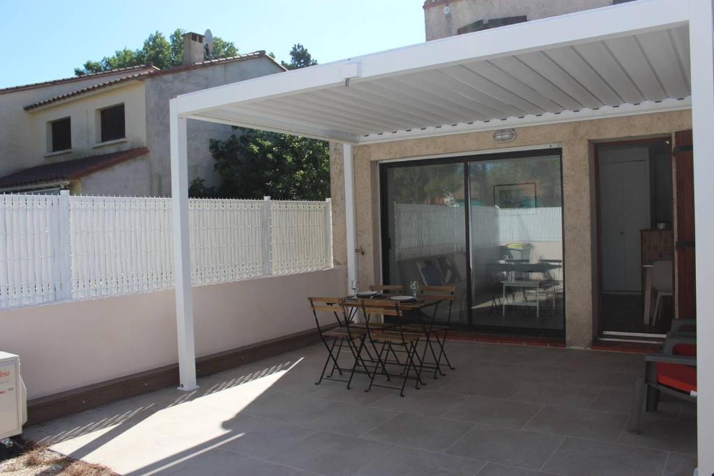 - un pavillon avec des chaises et une table sur la terrasse dans l'établissement T2 climatisé à 2 minutes de la plage du Pont Tournant - 4BRANR, à Saint Cyprien Plage