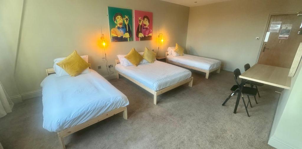 ニューカッスル・アポン・タインにあるWasters Arts Bar & Hotel, Contractor's Welcomeのベッドが2つと机とテーブルがある部屋