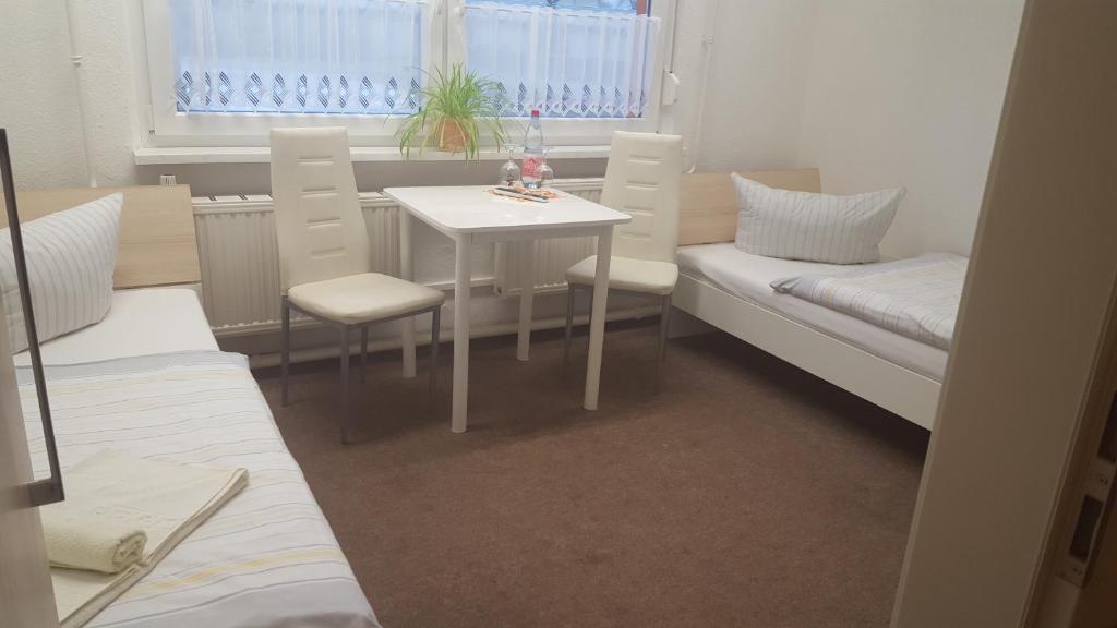 ein Zimmer mit einem Tisch und einem Sofa sowie einem Tisch und Stühlen in der Unterkunft Gästepension - Elsterland am Sport- und Freizeitpark in Elster