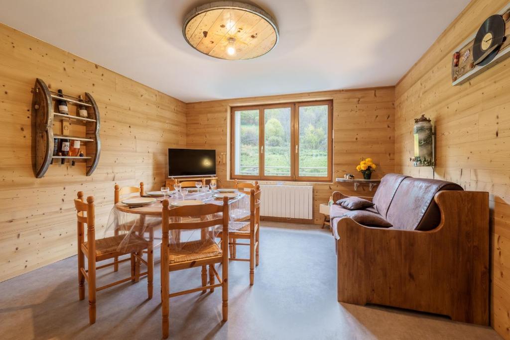 une salle à manger avec une table et un canapé dans l'établissement Les Jonquilles - 3 chambres et garage privé, à Cornimont