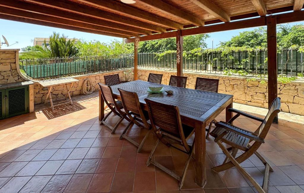 ein Holztisch und Stühle auf einer Terrasse in der Unterkunft 3 Bedroom Nice Home In Marina Di Modica in Marina di Modica