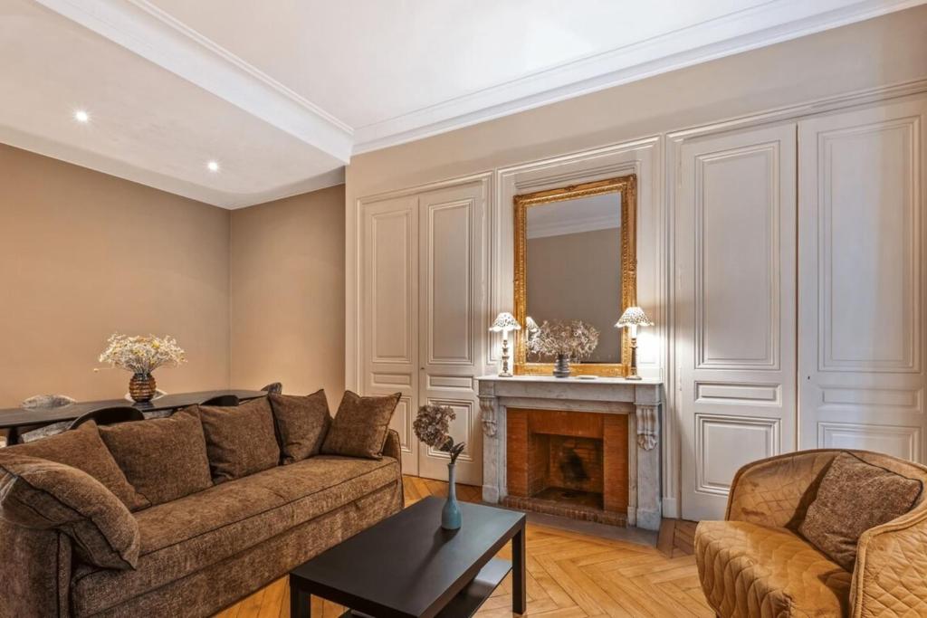 un salon avec un canapé et une cheminée dans l'établissement Le Vendôme - Elegance & Charm in the heart of Lyon's 6th arrondissement, à Lyon