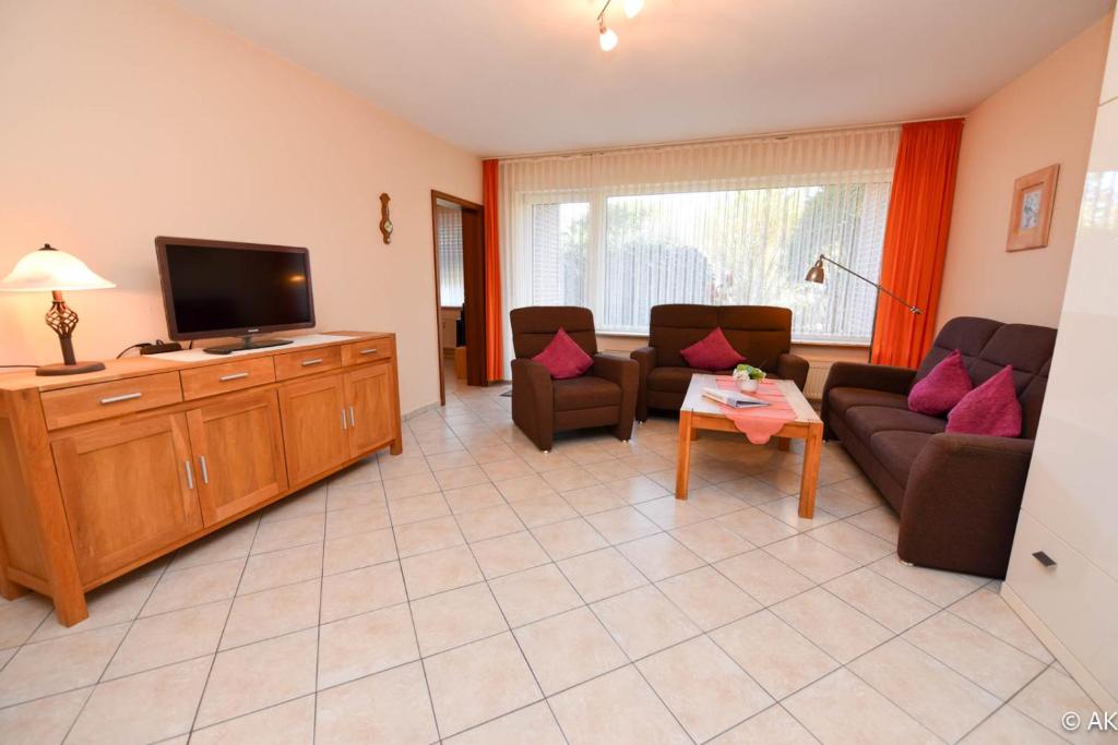 a living room with a couch and a tv at Haus "Luv und Lee" Appartement LEE01 in Döse