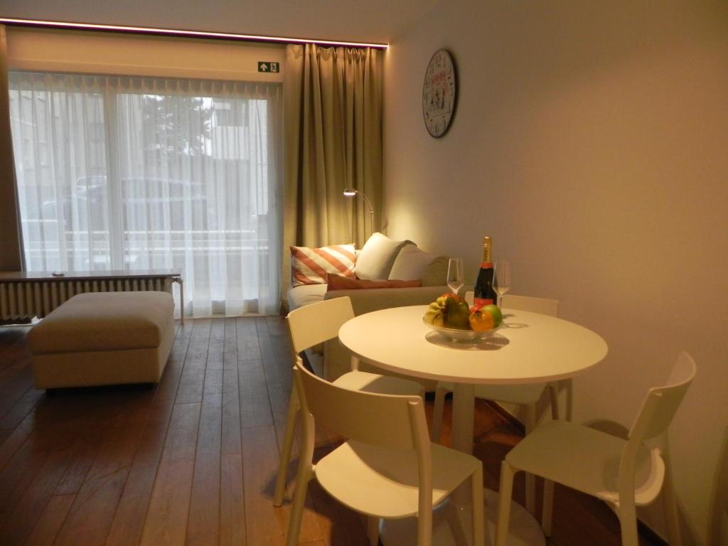 a living room with a table and chairs and a couch at Silver Sunrise Studio in De Haan