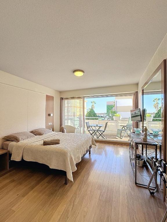 une chambre avec un grand lit et un balcon dans l'établissement Beau studio bord de mer à Villeneuve Loubet French Riviera, à Villeneuve-Loubet