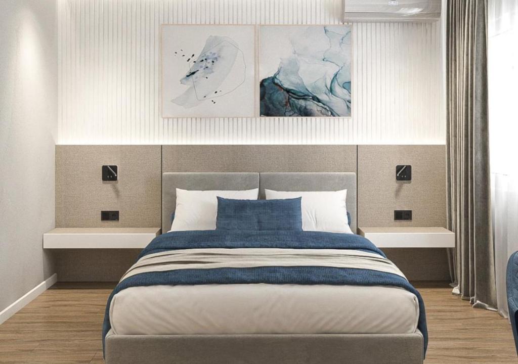 a bedroom with a large bed with two pictures on the wall at Sliv in Vinica
