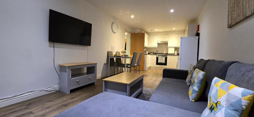 a living room with a couch and a flat screen tv at Ws Apartments - Luxury 1 bed in Watford Central in Watford
