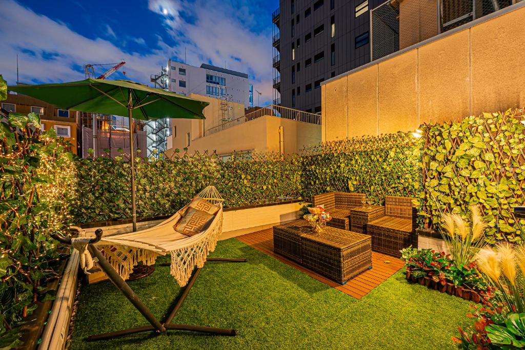 un patio con sombrilla, silla y banco en 春5GWifi TokyoDome皇居1km〜 RoofGarden 上野秋葉原銀座東京2km～都心, en Tokio