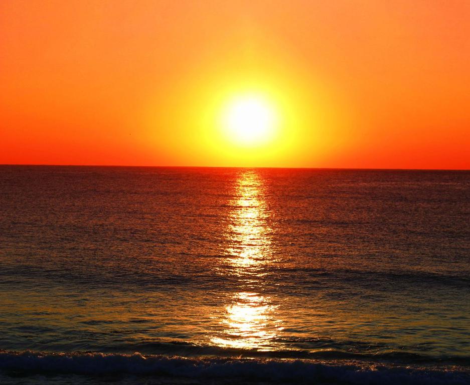 a sunset over the ocean with the sun setting at GranVista角島 in Oyama