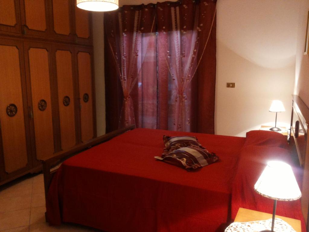 una camera con un letto rosso e un divano rosso di B&B Rosa Dei Venti a Orvieto